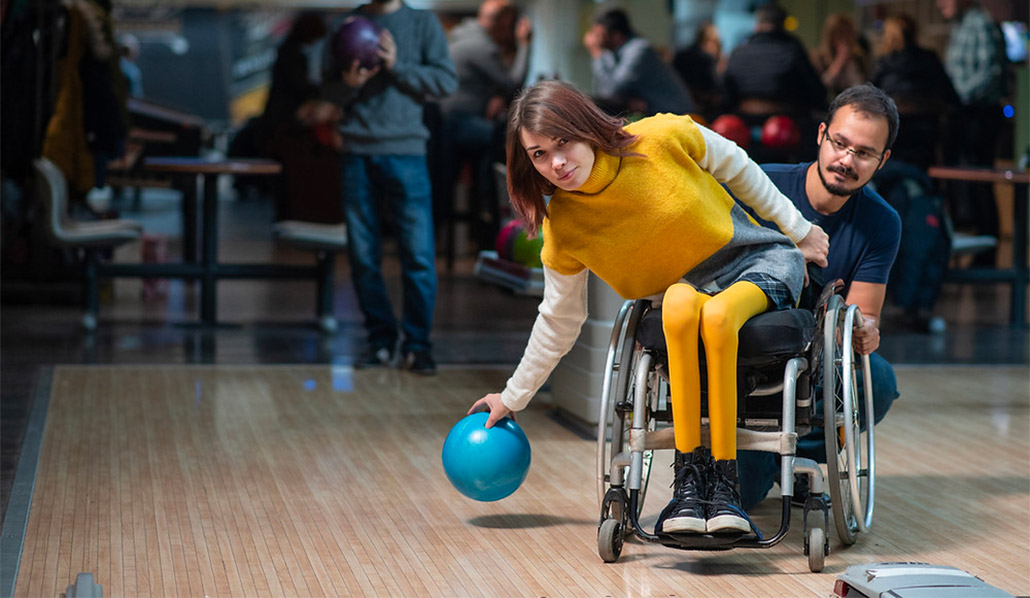 Person with a support worker bowling