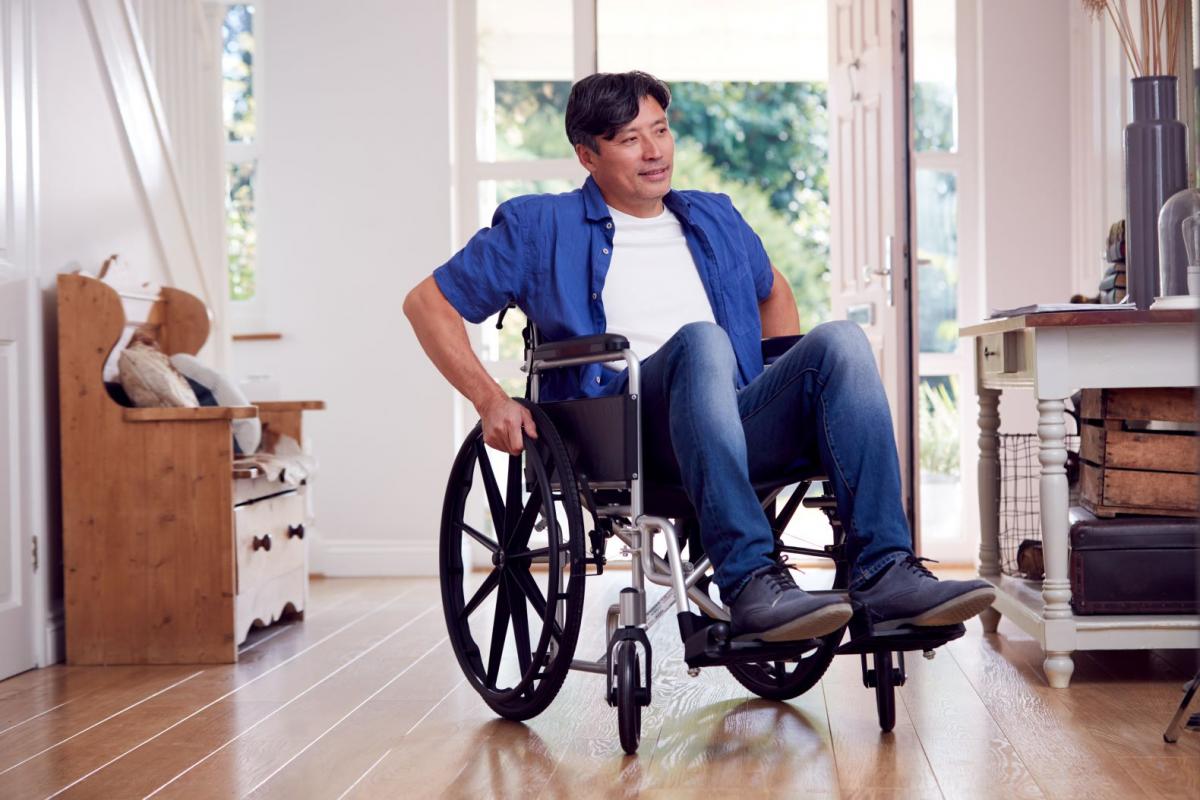 Gentleman seated in wheelchair at entrance of home