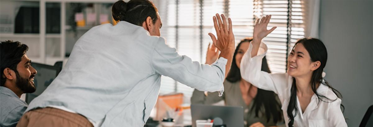 Two people high fiving each other