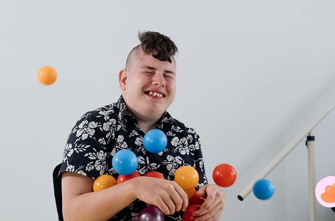 Young boy playing with balls and smiling