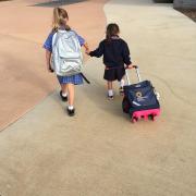 Maia and her sister holding hands walking off