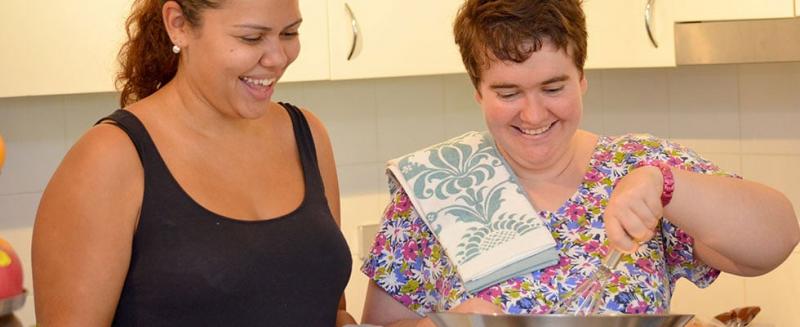 Support worker helping a woman cook