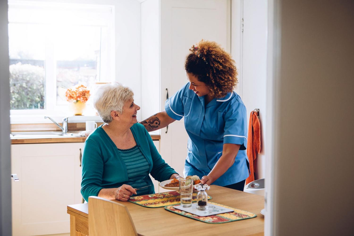 Support worker helping a person at the table