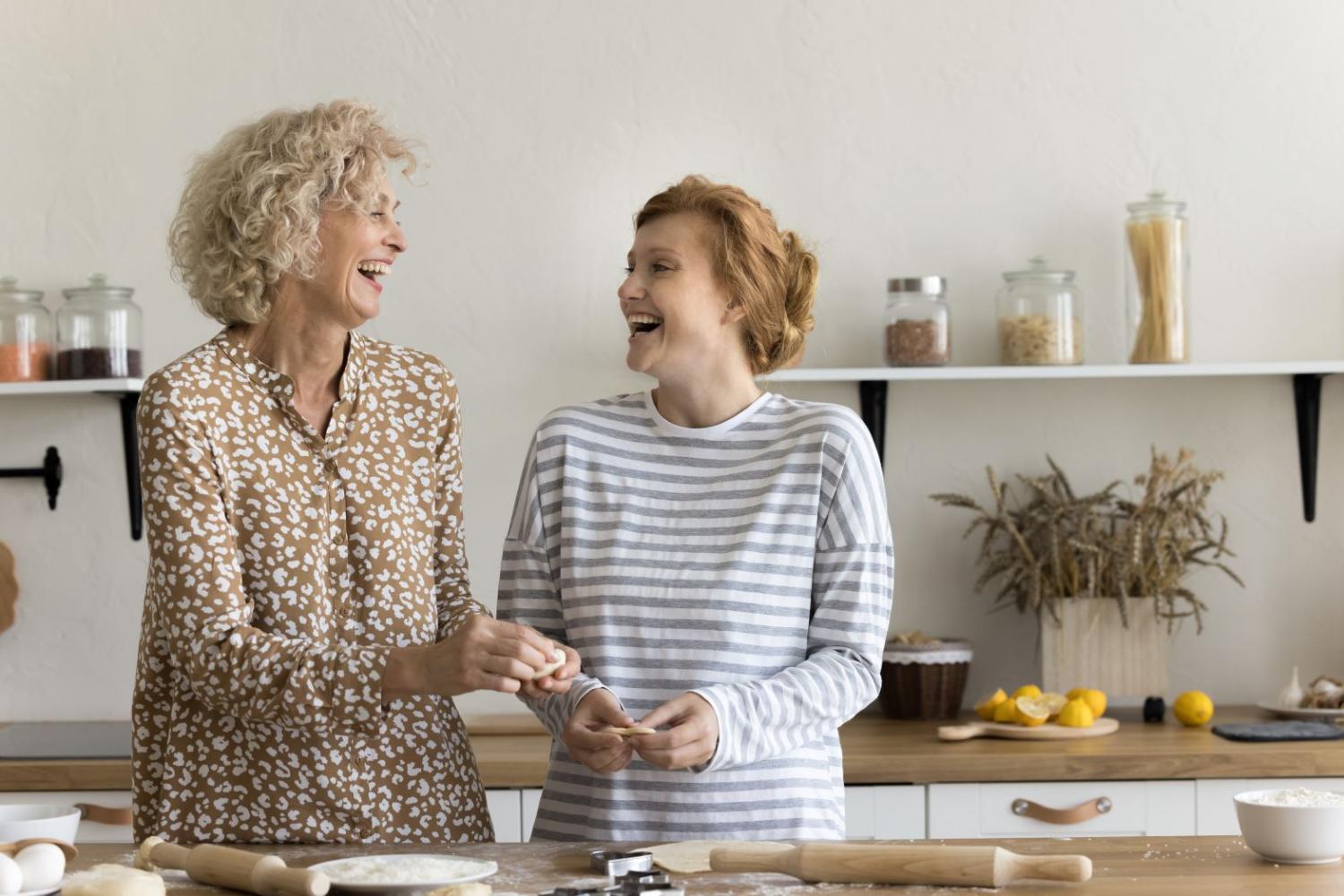 Woman with carer preparing dough in kitchen