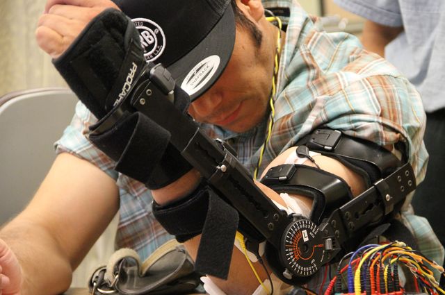 Man with spinal cord injury tests out device on arm to regain movement and strength