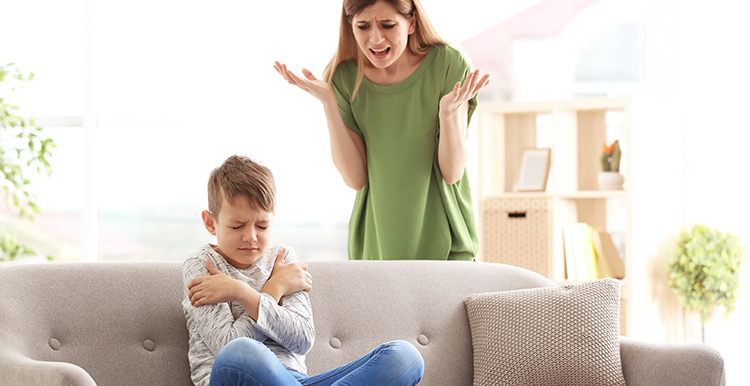 mother shouting at ADHD child sitting on couch