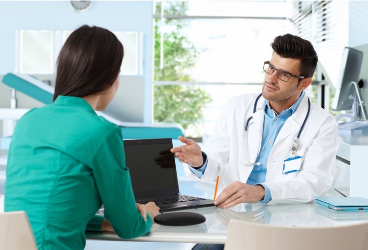 doctor consults with a patient at his desk