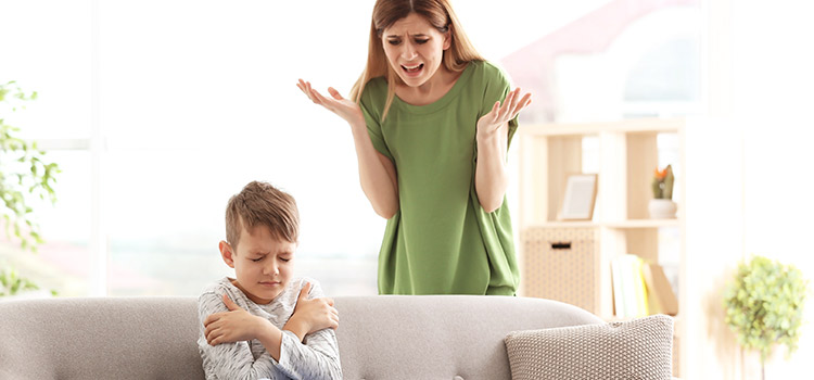 Mum getting frustrated with child who is upset and hugging himself