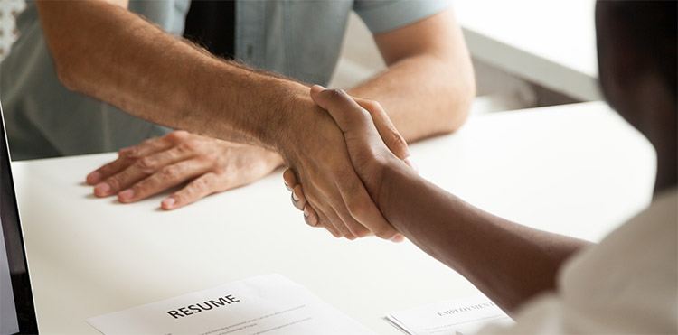 Employer shaking hands with new support worker