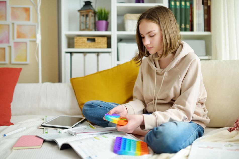 Young girls sitting on bed playing with sensory tool