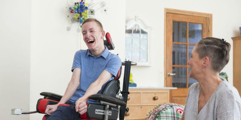 Young man in wheelchair with housemate