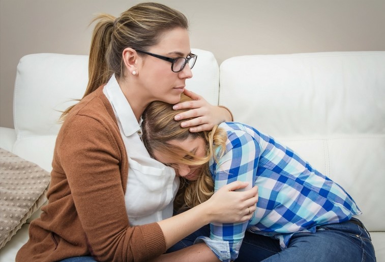 a woman hugs a sad woman in a warm embrace