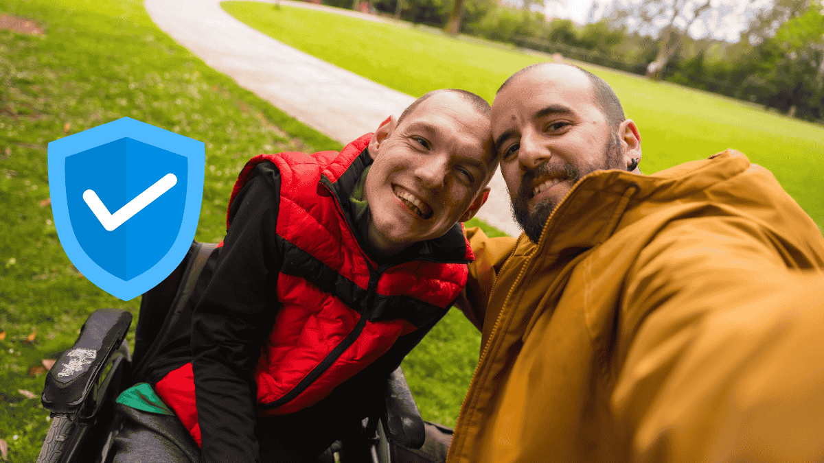 support worker with a a man in wheelchair smiling