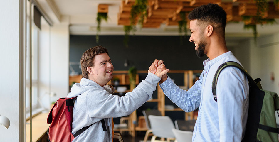 Young man shaking hands high five style with his support worker