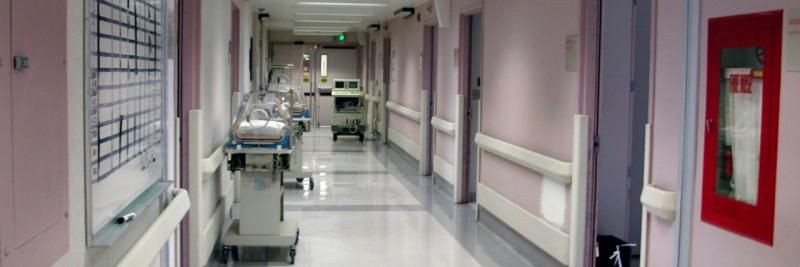 Image of a hallway in the nicu area of a hospital, with baby beds and equipment sitting in the hallway