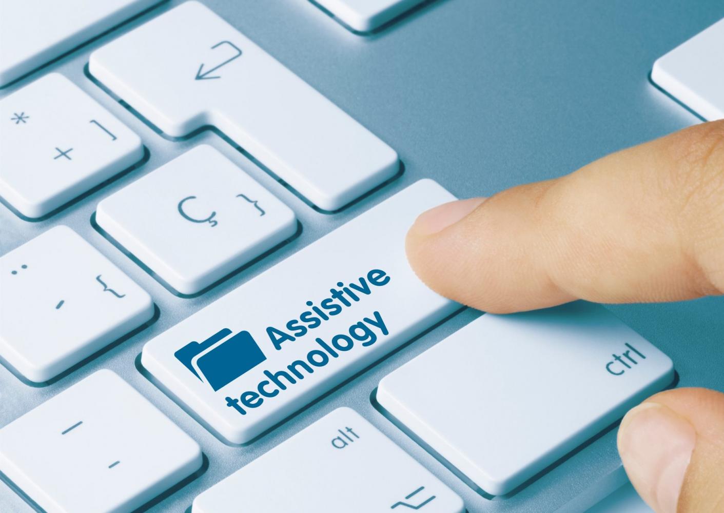 Person pressing a key on a computer keyboard. The key has the text Assistive Technology printed on it