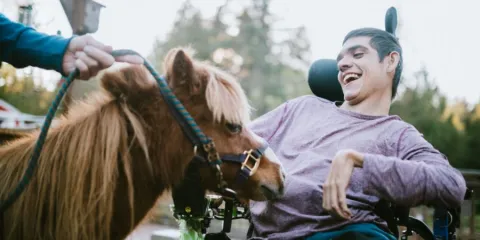 autistic person with complex needs patting a horse