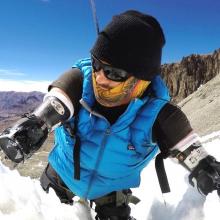 Kyle Maynard climbing up a snow covered mountain