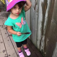 Maia wearing a pink hat at kindy