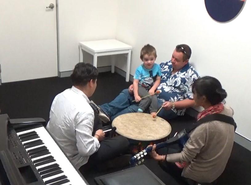 Darcy sitting on his fathers lap in the music lab