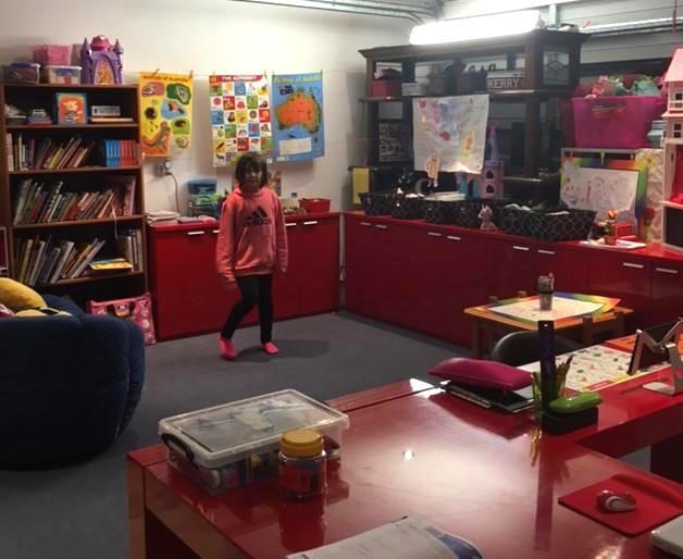 Chantae standing in her home school classroom surrounded by games and books