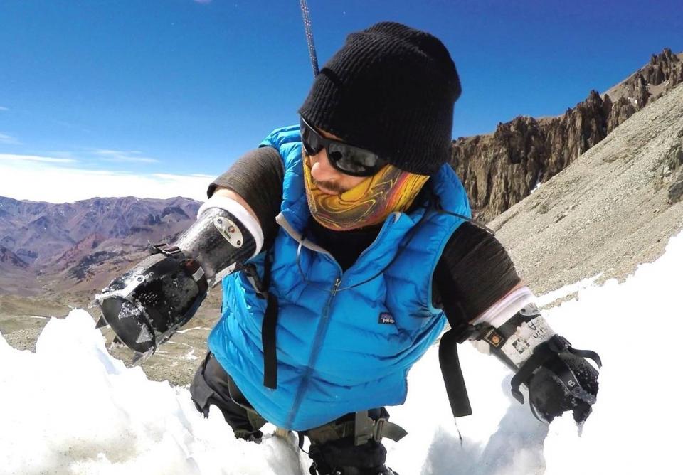 Kyle Maynard climbing up a snow covered mountain