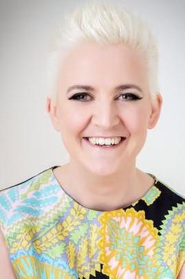 Libby smiling in a brightly printed op shop dress