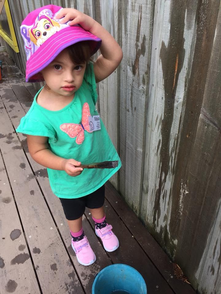 Maia wearing a pink hat at kindy