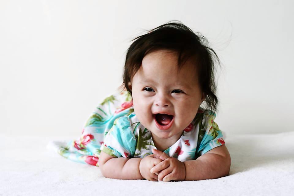 Close up portrait of Maia smiling and lying on her stomach