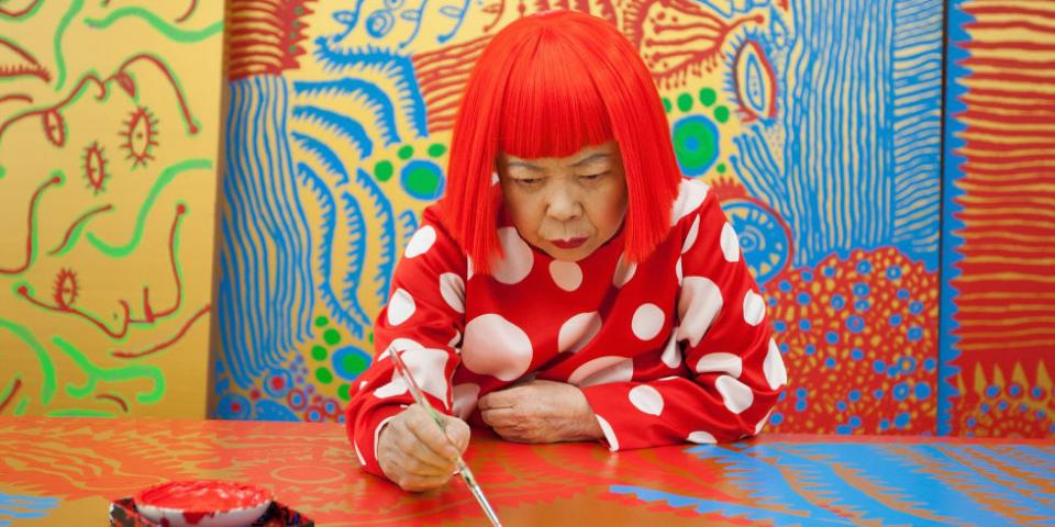 Yayoi deeply focuses on painting, and she has bright red hair and a red polka dot shirt