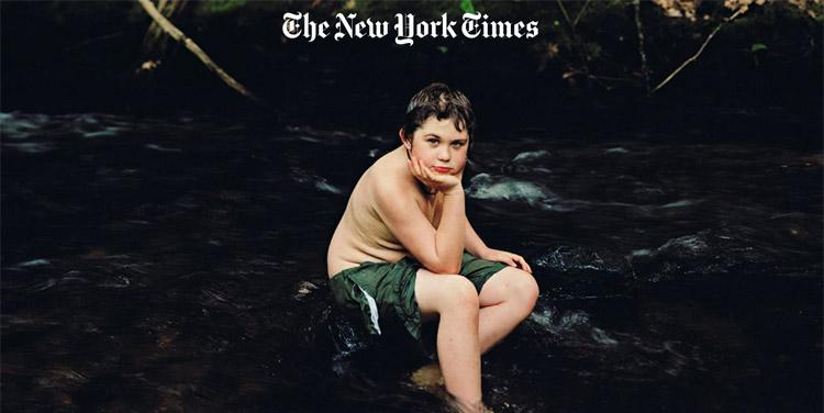 Boy sitting in waterfall