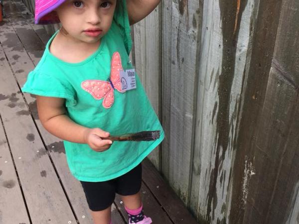 Maia wearing a pink hat at kindy