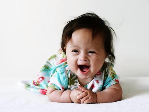 Close up portrait of Maia smiling and lying on her stomach